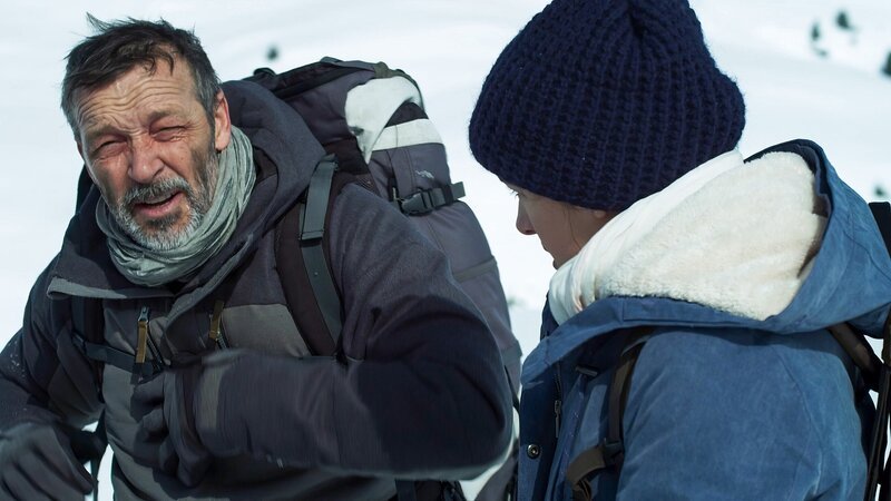 Roland (Michael Roll, l.) und Valerie (Marie Nasemann, r.) sind auf den Weg zu einer Berghütte. Der schneeblinde Roland sieht immer schlechter. – Bild: ORF/​ZDF/​Tobias Platow