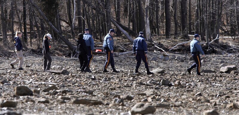 Ein Suchteam aus Staatspolizei und FBI-Agenten sucht nach Überresten von sechs vermissten Bootsfahrern und Fischern entlang der freigelegten Küste des Round Valley Reservoirs in Clinton Township, N.J., Mittwoch, 8. März 2006. Die Fälle vermisster Personen reichen bis ins Jahr 1973 zurück – Bild: MIKE DERER /​ AP /​ AP