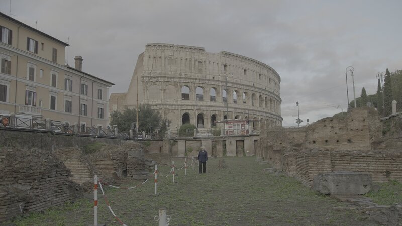 Professorin für Archäologie Valerie Higgins zu Fuß durch die Ruinen vor dem Kolosseum in Rom, Italien. – Bild: Disney+