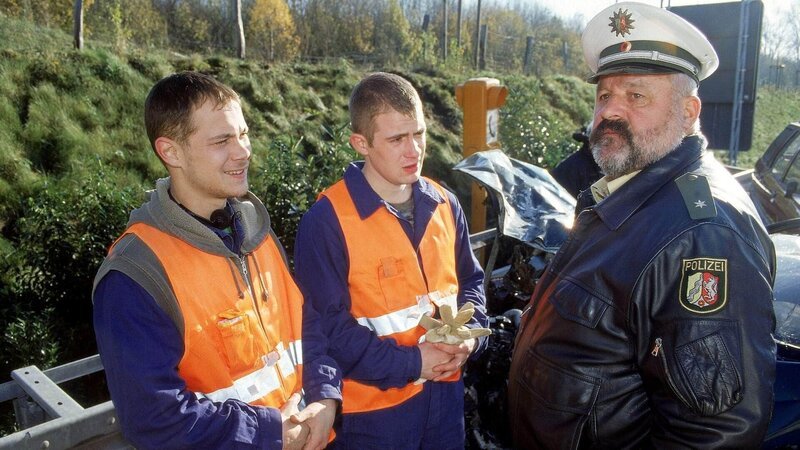 Die beiden Autobahnmeister Marko Heinrich (Antonio Wannek, li.) und Axel Kapellski (Aaron Tristan Hildebrand, Mi.) verstecken den gefundenen Koffer vor Polizist Herzberger (Dietmar Huhn). – Bild: MG RTL D /​ Guido Engels