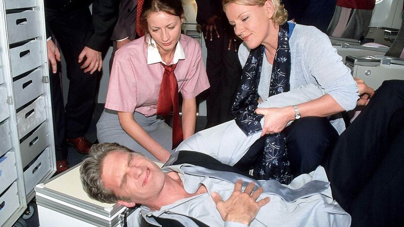 Das kommt davon: Weil Dr. Schmidt (Walter Sittler) sich nicht anschnallen wollte, hat es ihn bei Turbulenzen heftig erwischt. Nikola (Mariele Millowitsch, r.) muss helfen. (l. Sylvia Esch als Stewardess) – Bild: RTL