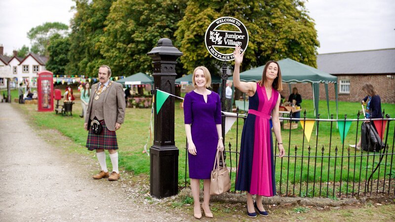 Der Gemeinderatsvorsitzende Mr. Macintosh, Emilys Mutter Pamela Parks und die Lehrerin Miss Murphy wollen bei der Jury, die gerade eintrifft, einen guten Eindruck machen, damit sie den Wettbewerb „Das schönste Dorf“ auf jeden Fall gewinnen. – Bild: ZDF/​Kind Of Productions Limited MMXXIII
