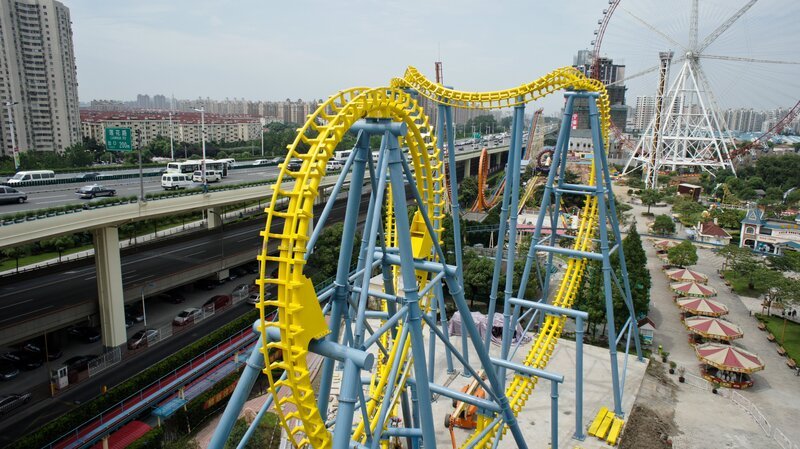 Shanghai, China: An aerial view of the Giant Inverted Boomerang roller coaster ride shows it situated adjacent to Shanghai’s highway while on the edge of the Jinjiang Action Park. – Bild: Steel Spyda USA, LLC