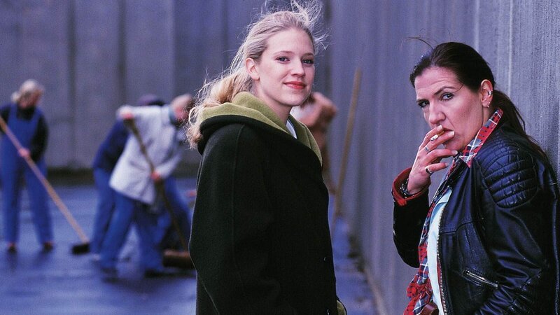 Blondie (Victoria Madincea, l.) lächelt dem vorbeilaufenden Gitting zu – Walter (Katy Karrenbauer) ist etwas irritiert. – Bild: RTL Deutschland