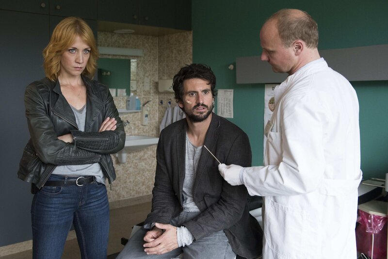 Als Dr. Rössler (Christian Hockenbrink, r.) Felix (Tom Beck, M.) und Elena (Annika Ernst, l.) mitteilt, dass die Drogen, die Felix untergeschoben wurden, ihn an den Ausbruch der Erbkrankheit Chorea Huntington glauben ließen, will sich dieser nur noch an der verhassten Sektenführerin Ambrosia rächen … – Bild: SAT.1 /​ Martin Rottenkolber Eigenproduktionsbild frei