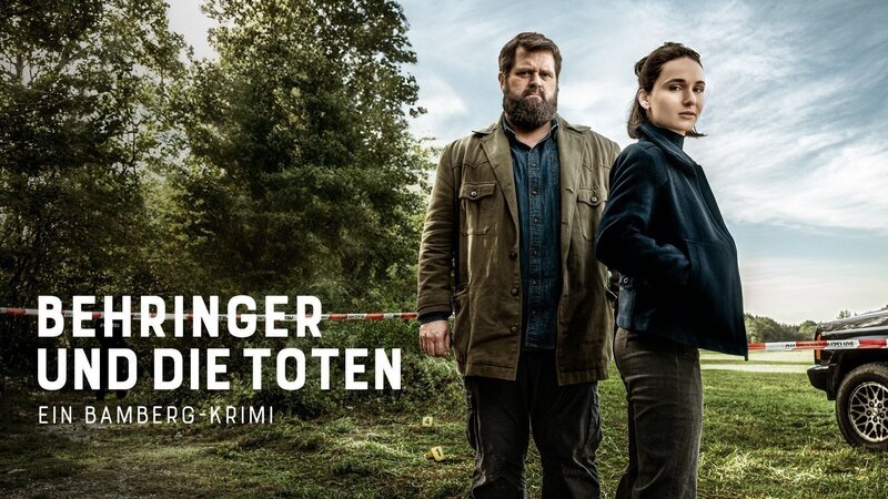 Das Keyart zu „Behringer und die Toten“ mit Behringer (Antoine Monot) und Ela (Cosima Henman) – Bild: RTL/​ Redseven Entertainment/​ Florian Froschmayer