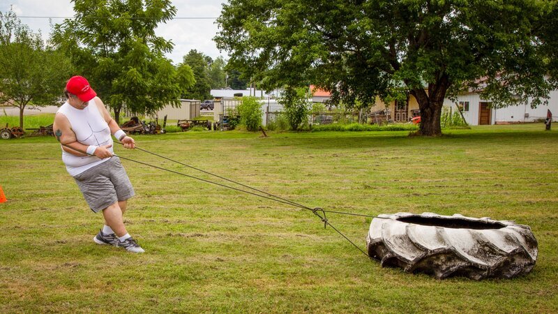 Chris pulls a tire as part of a workout his family is making him do. – Bild: Cloud To Ground/​Crazy Leg Productions