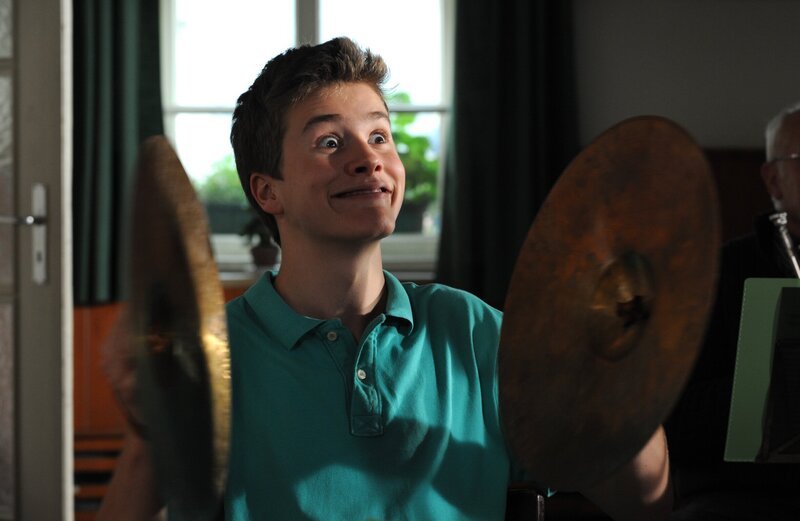 Patrick (Lucas Bauer) langweilt sich in der Kapelle und sucht sich Ablenkung. – Bild: BR/​Marco Orlando Pichler