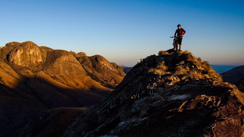 Ein Radfahrer steht auf einem Hügel. – Bild: Hip Trips