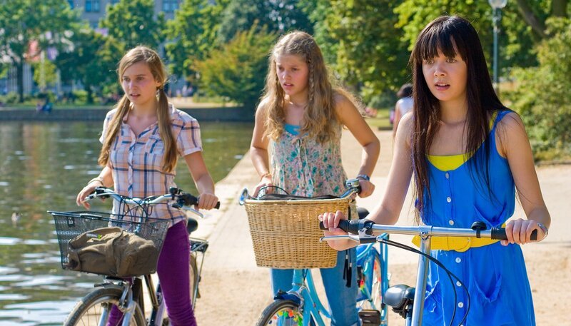 Die Freundinnen sind bestürzt, als Jackies Tasche mit dem Handy in den See fällt. v.r.: Ally (Marny Kennedy), Emma (Sophie Karbjinski), Jackie (Charlotte Nicdao). – Bild: NDR/​Southern Star