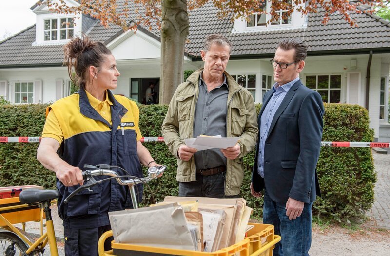 Finn (Sven Martinek, M.) und Lars (Ingo Naujoks, r.) machen in Claasens Post einen interessanten Fund (mit Komparsin, l.). – Bild: ORF/​ONE GATE/​ARD/​Thorsten Jander