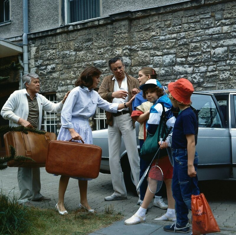 Bernie (Heinz Baumann, m.) – der geschiedene Mann von Angi (Thekla Carola Wied) – holt die Kinder Tom (Tarek Helmy), Tanja (Julia Biedermann) und Markus (Timmo Niesner) zur Reise nach Italien ab. Werner (Peter Weck) darf wieder Koffer schleppen. – Bild: Nova Film