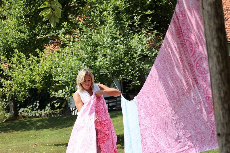 Theresa Schöffel beim Aufhängen der Stoffe während ServusTVs ‚Bei mir Daheim‘ in Stainz, STMK – Bild: Monika Roidmayr /​ Terra Mater Factual Studios /​ Terra Mater Studios GmbH