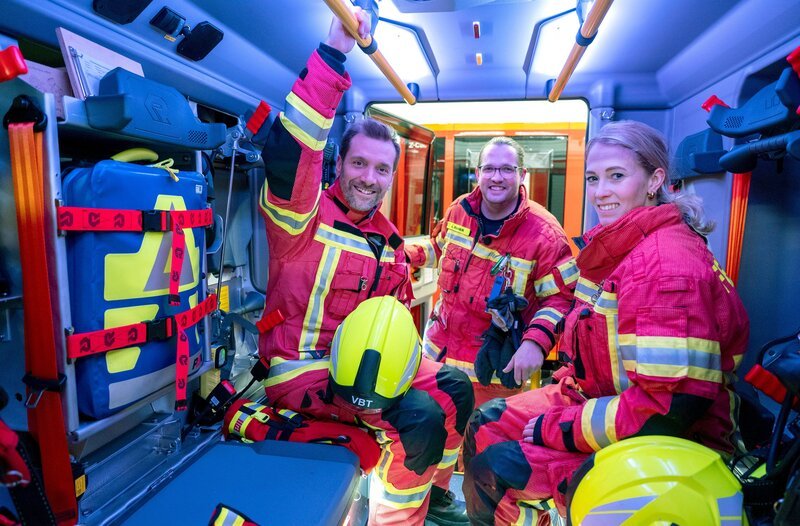 So sieht es in einem Feuerwehr-Auto aus! Joel Kaiser (m.) und Adriana Schröder nehmen WDR-Reporter Daniel Aßmann mit in die Welt der freiwilligen Feuerwehr. – Bild: WDR/​solis TV/​Melanie Grande