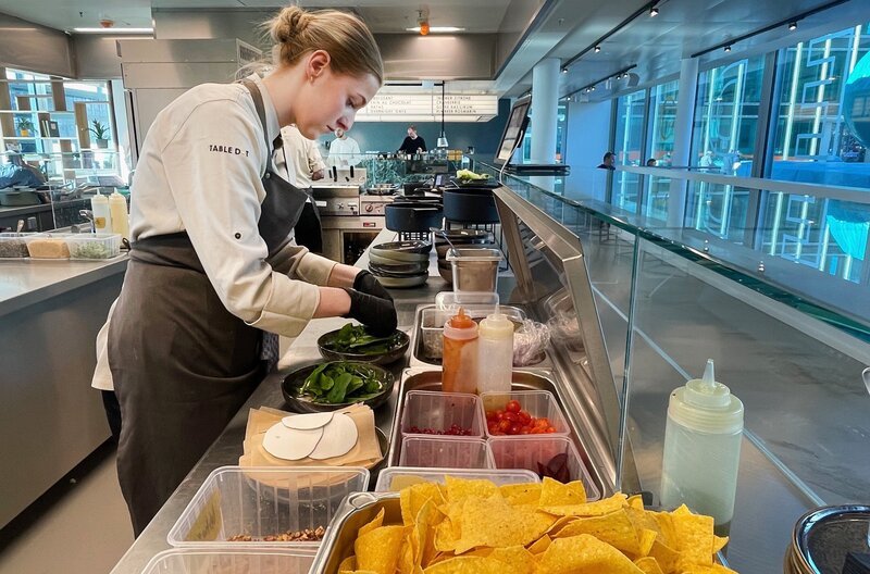 Charlotte Walker bereitet einen Salat im "Table Dot", einer modernen Kantine, zu. – Bild: NDR/Eco Media Charlotte Walker bereitet einen Salat im "Table Dot", einer modernen Kantine, zu. – Bild: NDR/Eco Media