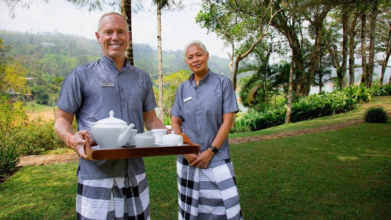 Die Moderatoren Rob Rinder und Monica Galetti servieren Tee in den Butler-Uniformen im Hotel Ceylon Tea Trails in Sri Lanka. – Bild: SRF/​BBC Studios