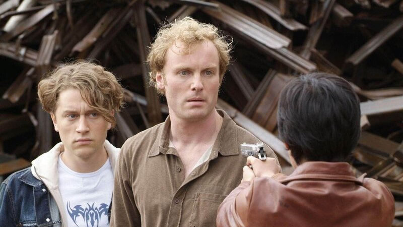 Kaum hat Sven (Mark Waschke, Mi.) Thilo (Adrian Topol, li.) aus Lennerts Schusslinie gebracht, da steht Anja (Mandala Tayde) plötzlich mit gezogener Waffe vor ihnen … – Bild: MG RTL D /​ Guido Engels