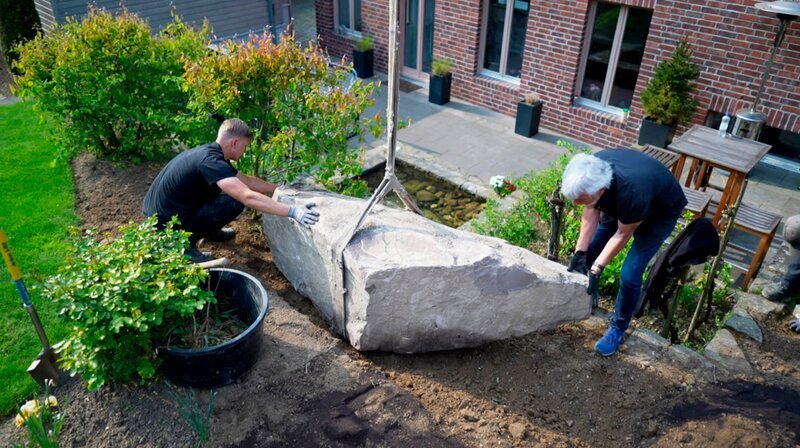 Peter Berg und sein Mitarbeiter legen den ersten Stein im Garten. – Bild: SWR