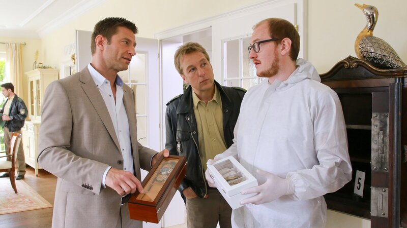 Am Tatort stellen die Rosenheimer Ermittler (v.l.n.r.: Igor Jefti?, Max Müller, Norbert Ortner) fest, dass es sich hier um Raubmord handelt. – Bild: ZDF und Christian A. Rieger