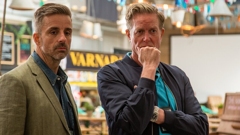 Dan Sommerdahl (Peter Mygind, r.) und sein Freund und Kollege Flemming Torp (André Babikian) ermitteln gemeinsam in einem Mordfall in der Markthalle von Helsingør. – Bild: Mike Kollöffel /​ ZDF