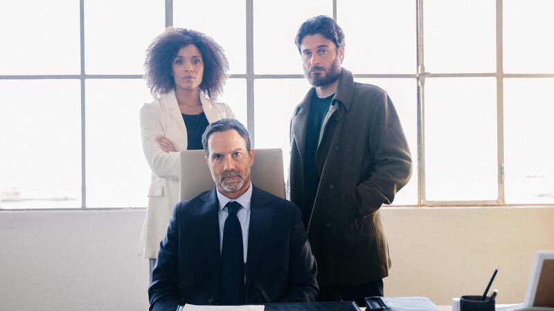 Sylvie (Stéfi Celma, l.), ihr Mann Luca (Lino Guanciale, r.) sowie dessen bester Freund Stefano (Fausto Sciarappa, M.) beraten das weitere Vorgehen in einem Büro der Werft. – Bild: Matheus Bertoni