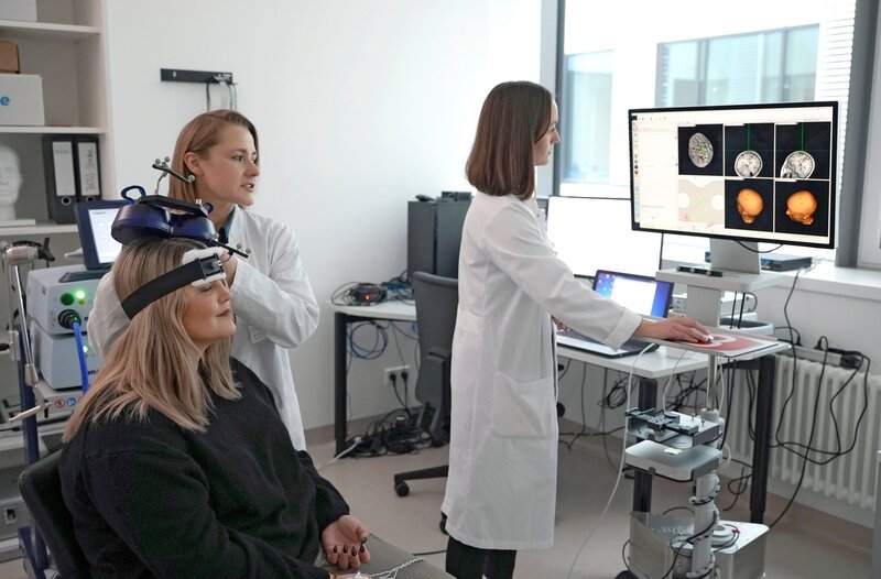 Katharina Borck probiert eine innovative Methode an der Uniklinik Frankfurt a.M., um ihre gelähmte Hand wieder ansteuern zu können. – Bild: HR/​Luca Zanner