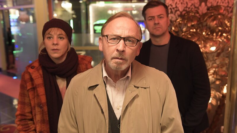 In der Spielhalle Nevada gehen die Kommissare Ludwig Schaller (Alexander Held, M.), Angelika Flierl (Bernadette Heerwagen, l.) und Harald Neuhauser (Marcus Mittermeier, r.) der Spur nach, ob das Opfer Rudi als Doppelgänger gebucht worden ist. – Bild: ZDF und Jürgen Olczyk