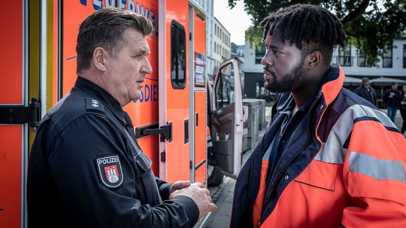 Hans (Bruno F. Apitz, l.) und Dr. Schmidt (Joel Williams, r.) unterhalten sich über den Fall. – Bild: Boris Lasewen /​ ZDF