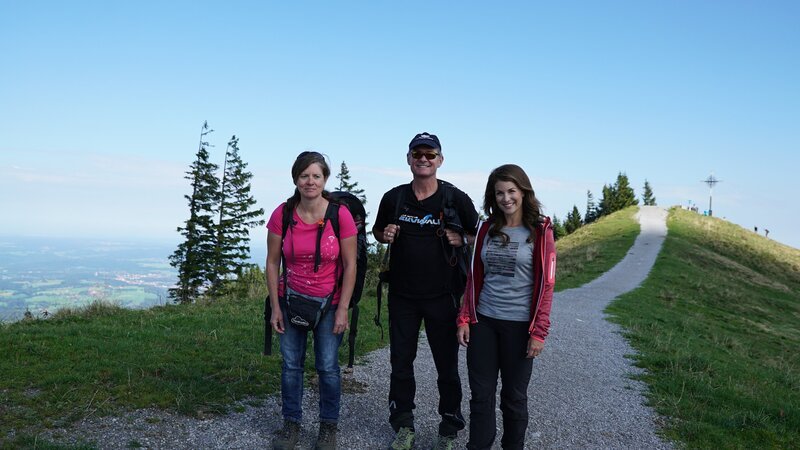 Die Rekord-Gleitschirmflieger Renate Brümmer (links) und Burkhard Martens (Mitte) sind mit Moderatorin Claudia Pupeter auf dem Weg zum Gleitschirmfliegen. – Bild: BR/​south & browse GmbH