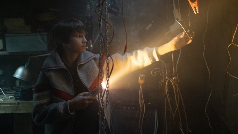 Profile: WILL inspects an alligator clamp hanging from the ceiling with his flashlight in the basement. – Bild: TLC