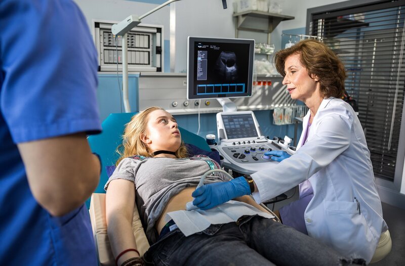 Florian Osterwald (Lion Wasczyk, l.) und Prof. Dr. Karin Patzelt (Marijam Agischewa, r.) untersuchen die Patientin Finja Behring (Johanna Götting, M.) in der Schockbox der Notaufnahme des JTK. – Bild: ARD/​Michael Kremer