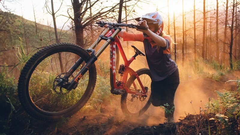 Eine Frau schiebt ein Fahrrad einen Hügel hinauf – Bild: Hip Trips