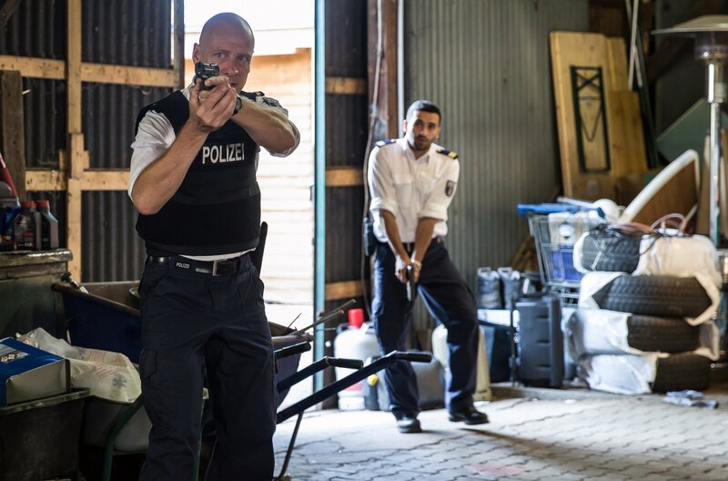 Wolf Malletzke (Christoph Grunert, li.) und Fahri Celik (Hassan Akkouch, re.) bei einem bewaffneten Einsatz in der Marina. – Bild: ARD/​Daniela Incoronato