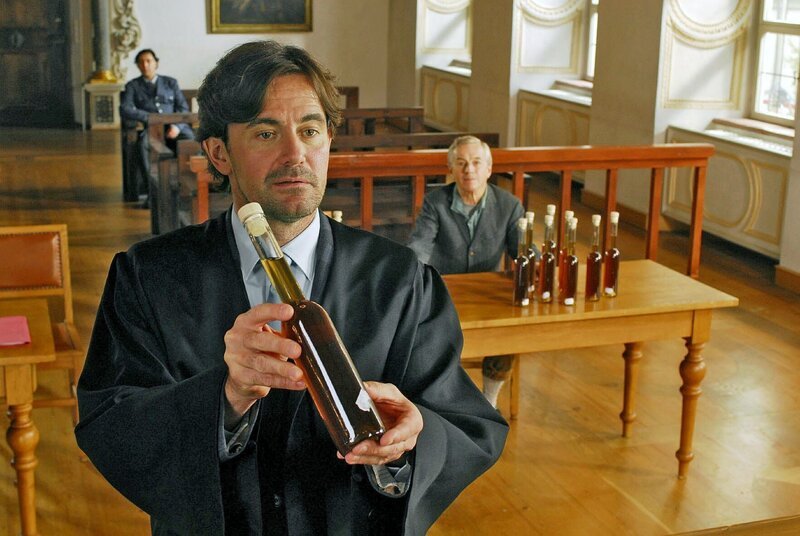 Während Staatsanwalt Mayerle eine flammende Rede gegen den illegalen Schnapsbrenner Laurenz Pirngruber (Gerd Lohmeyer, r.) hält, preist Frebert (Robert Lohr, l.) die hervorragende Qualität des Magenbitters an und fordert vehement die Wiederbelebung dieses verschütteten Kulturguts. – Bild: SAT.1 /​ Hans Seidenabel Eigenproduktionsbild frei