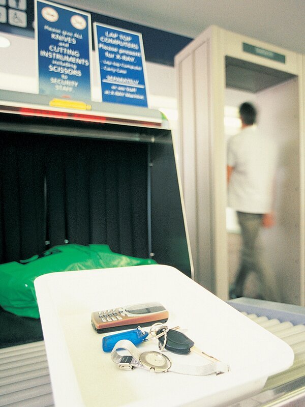 Two People Walking Through a Metal Detector at Airport Security – Bild: James Lauritz /​ Getty Images /​ GettyImages-dv776112