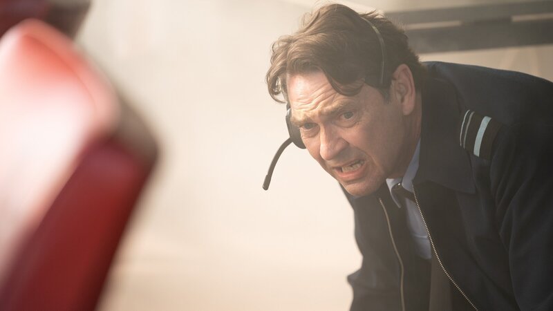Air Marshal Marcus Grainger (Dougray Scott) muss sich wegducken, als bei einer Vorführung die Drohnen außer Kontrolle geraten und ins Publikum feuern. – Bild: ZDF und Jamie Simpson /​ WORLD PRODUCTIONS LTD
