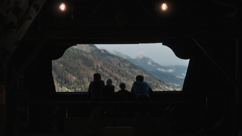 Helene & Pepi Klingesberger und ihre beiden Kinder blicken aus dem Stadl der Hepilodge ins Tal. – Bild: QUERSCHUSS FILM /​ ServusTV