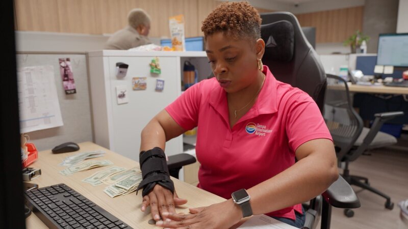 Tahini zählt Geld an ihrem Schreibtisch. – Bild: National Geographic