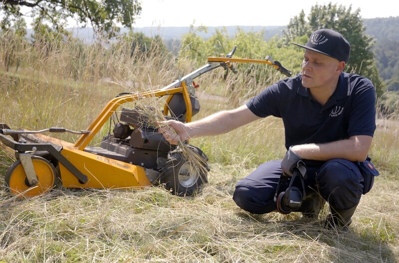 Fachwart für Obstanbau Dennis Mohr mäht seine Streuobstwiesen immer sehr spät im Jahr und lässt die Mahd auf der Wiese liegen, als Nährstofflieferant für die Bäume. – Bild: SWR/​teamWERK/​Dirk Schwarz