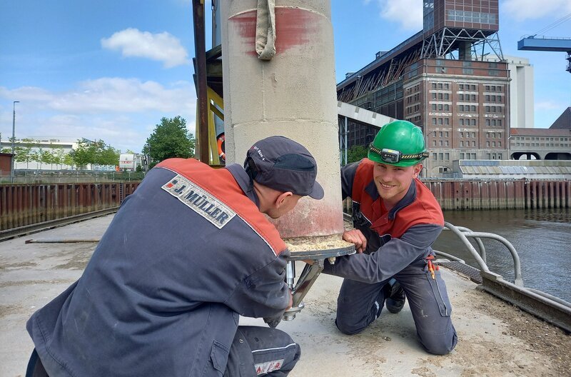 Technik Vorarbeiter Niels Kocerka bereitet mit einem Kollegen die Beladung eines Binnenschiffs mit Weizen aus dem Getreidespeicher vor. – Bild: NDR/​Thomas Karp
