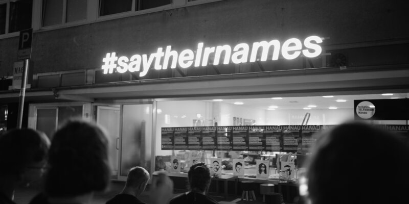 #saytheirnames leuchtet vom Vordach der „Initiative 19. Februar Hanau“ und wurde bundesweit zu einem wichtigen Slogan im Kampf gegen Rassismus. – Bild: ZDF und Marcin Wierzchowski