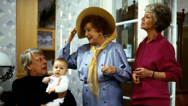 Oma Käthe (Edith Schollwer, M.) bereitet ihre Reise nach Palermo vor. Hannelore (Maria Sebaldt, r.) und Eberhard Wichert (Stefan Orlac, l.) sehen diesem Vorhaben eher skeptisch entgegen. – Bild: ZDF und Terranova