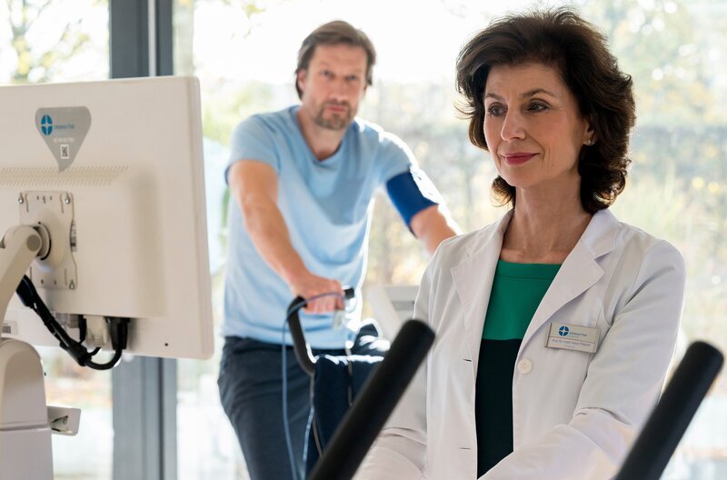 Prof. Patzelt (Marijam Agischewa, r.) übernimmt persönlich das Belastungs-EKG für ihren Patienten Frank Boger (Christoph Kottenkamp, l.). – Bild: ARD/​Jens Ulrich Koch