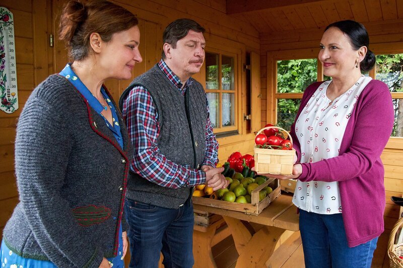 Frau Grasegger (Ursula Maria Burkhart, r.) hat in ihrem Schrebergarten zu viel Obst und Gemüse angebaut, sodass sie ihren Nachbarn Annegret (Eva Wittenzellner, l.) und Hartmut Nerlinger (Georg Veitl, M.) einen Teil davon schenkt. – Bild: ZDF /​ ORF /​ Bojan Ritan