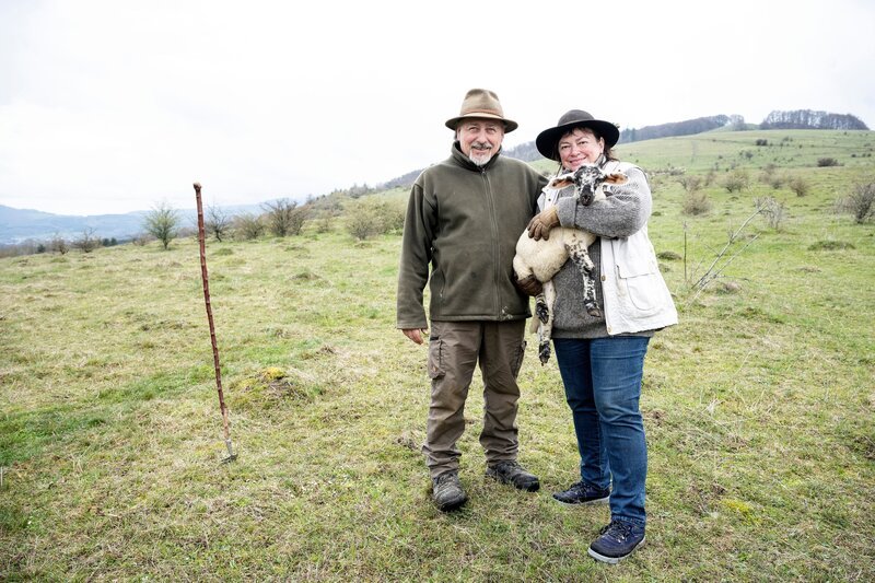 Heidi Sattes-Müller mit einem Lamm im Arm und Mann Harald Müller auf der Weide. – Bild: BR/​Rudi Ott/​Rudi Ott