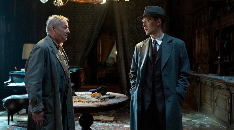 Wer hat den Mörder gesehen? Der Ermittler Jan Morava (Jonas Nay) befragt den Hausmeister (Markus Hering, li.). – Bild: ARD Degeto Film/​NDR/​Servus TV/​Canal+Austria/​HR/​Zeitgeist Filmproduktion/​EPO-Film/​Petro Domenigg