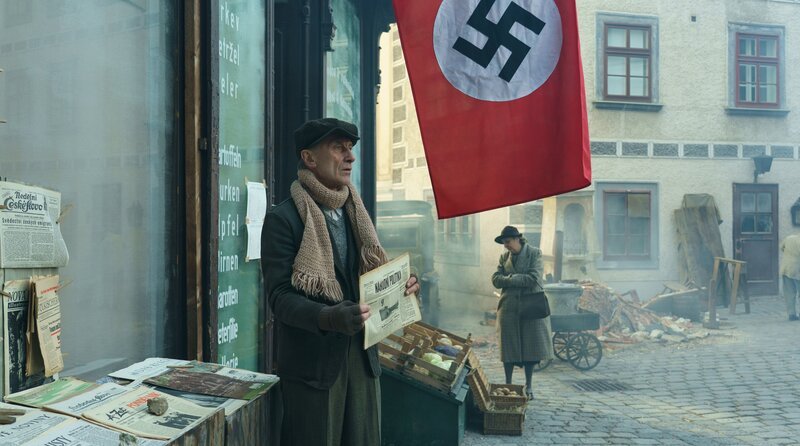 Wer erkennt den Mörder? Ein Kioskbetreiber (Klaus Schwarz) mit dem Fahndungsaufruf in der Zeitung. – Bild: ARD Degeto Film/​NDR/​Servus TV/​Canal+Austria/​HR/​Zeitgeist Filmproduktion/​EPO-Film/​Petro Domenigg