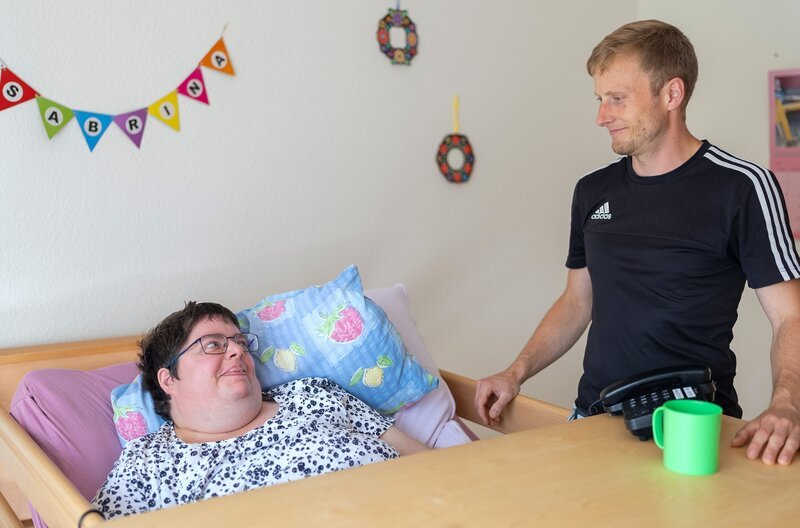 Erik Jahraus ist gelernter Physiotherapeut und macht eine weitere Ausbildung als Heilerziehungspfleger. Sein Arbeitstag beginnt mit Wecken und Körperpflege der Bewohner. – Bild: SWR /​ Elias Franke