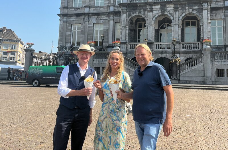 Gemeinsam mit Host Peter probieren Björn Freitag (r) und Tamina Kallert auf dem Markt in Maastricht die holländische Fritten-Spezialität: Frietjes speciaal. – Bild: WDR/​2bild GmbH/​Lisa Frising
