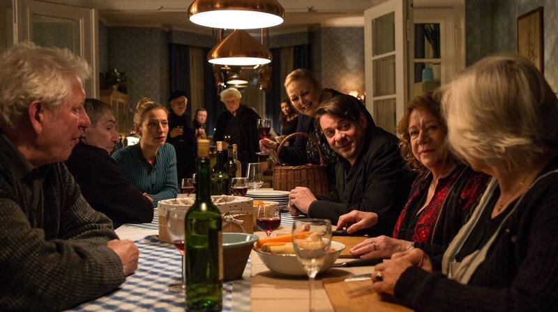 Jan Koller (Roeland Wiesnekker, 3. v. re.) wird von den Heimbewohnern zum Abendessen eingeladen. – Bild: Hannes Hubach
